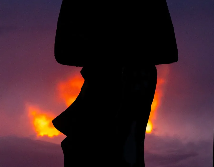 silhouette of a statue with a sunset behind