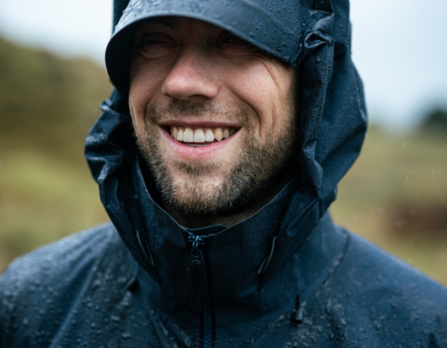 Man stood in rain and smiling