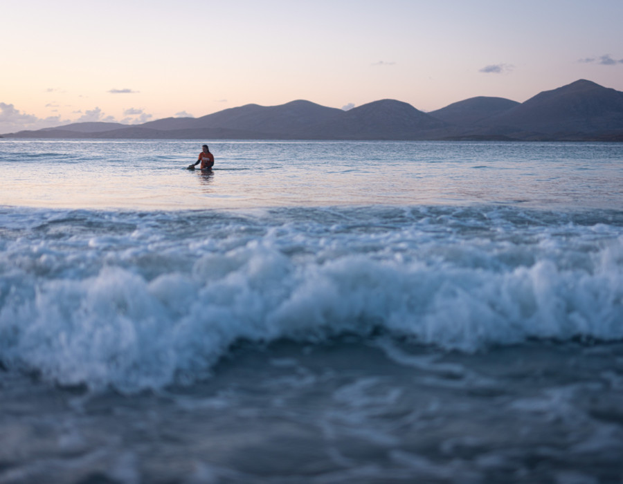 Participant stood in sea with colourful sky above