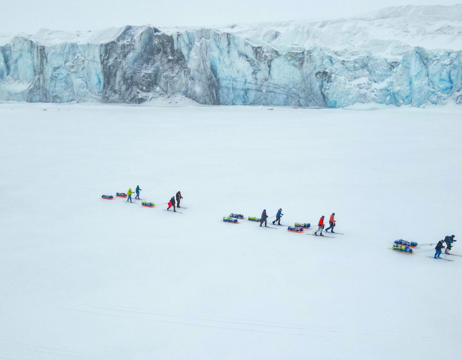 Participants pulling sleds through snowy terrain