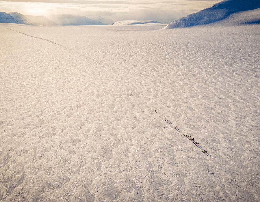 Aerial view of participants walking across frozen ground