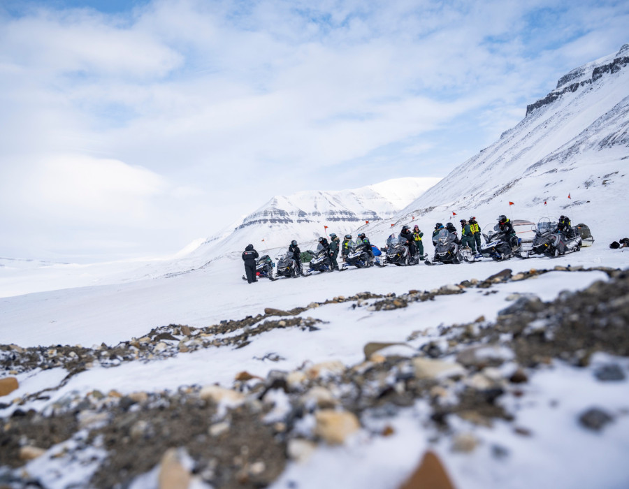 Participants stood on rocky and snow-covered terrain