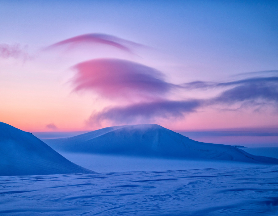 Colourdul sky with snow-covered mountains below