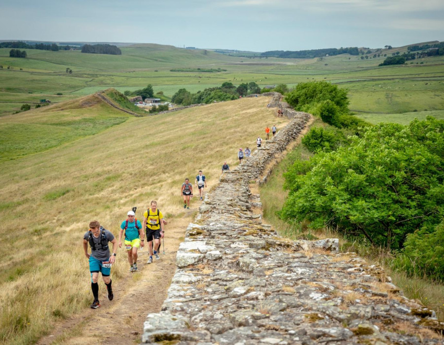 People walking beside wall