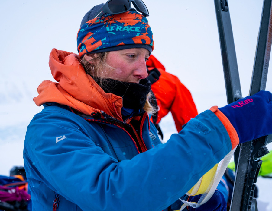 Woman holding equipment in a snowy, white environment
