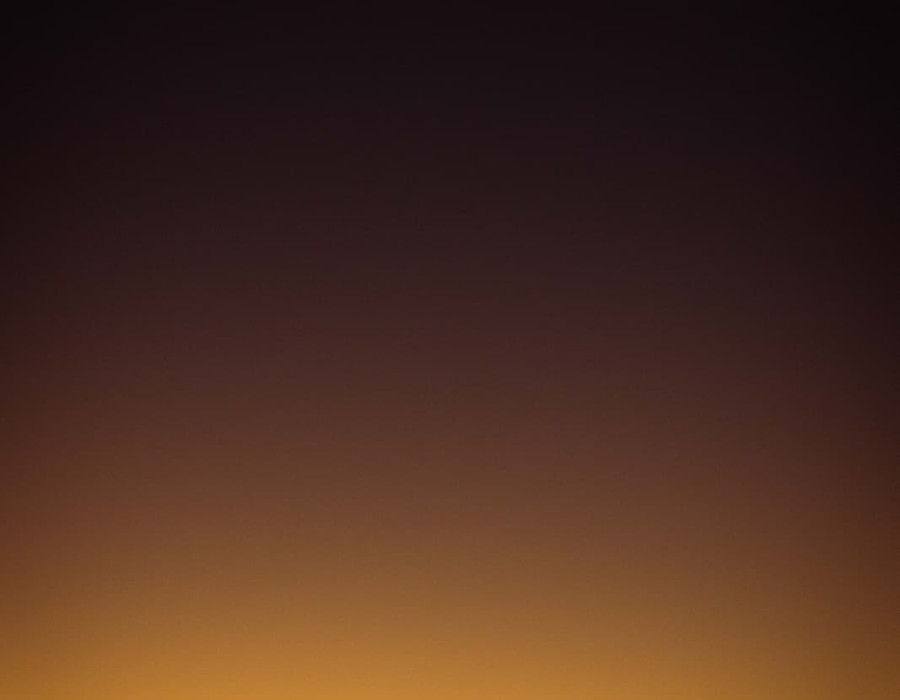 Silhouette of cyclist and colourful, dark sky above