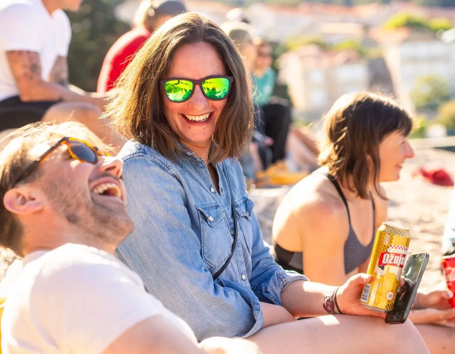 A man and a women laughing and surrounded by other happy people
