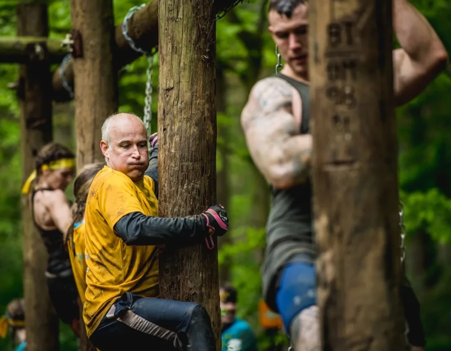 Men and women hanging onto wooden poles