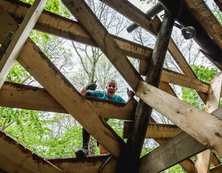 Man, putting his thumbs up and standing on wooden planks