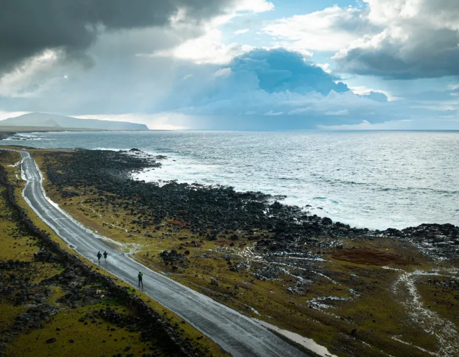Participants running along a coastal road