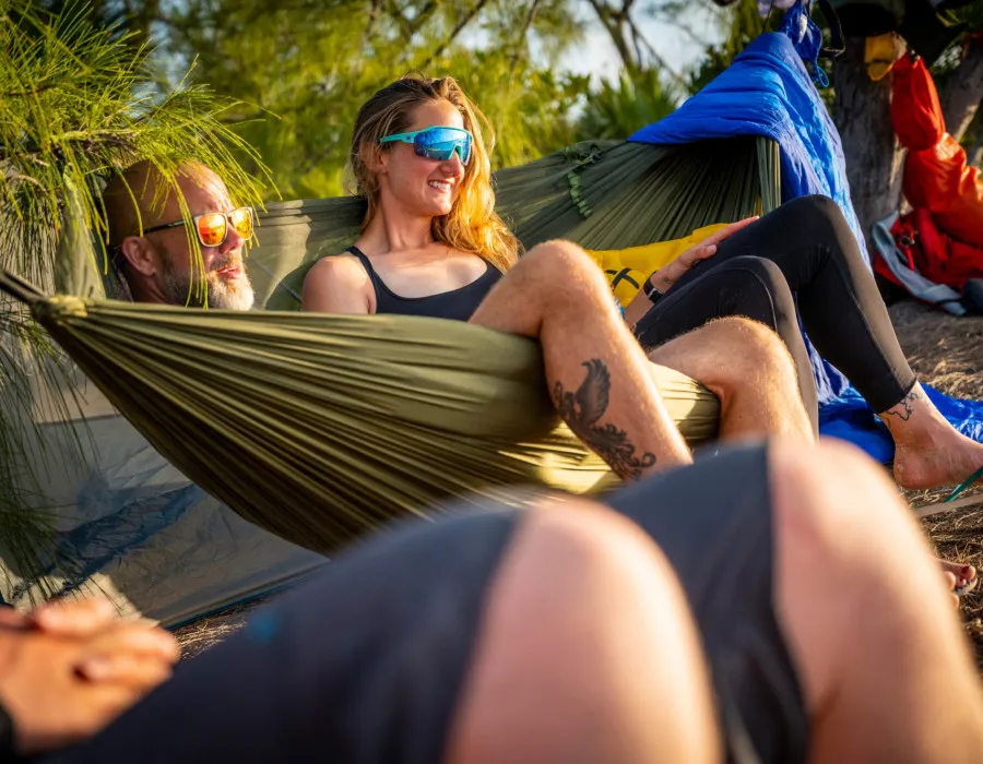 Participants resting in a hammock on a beach