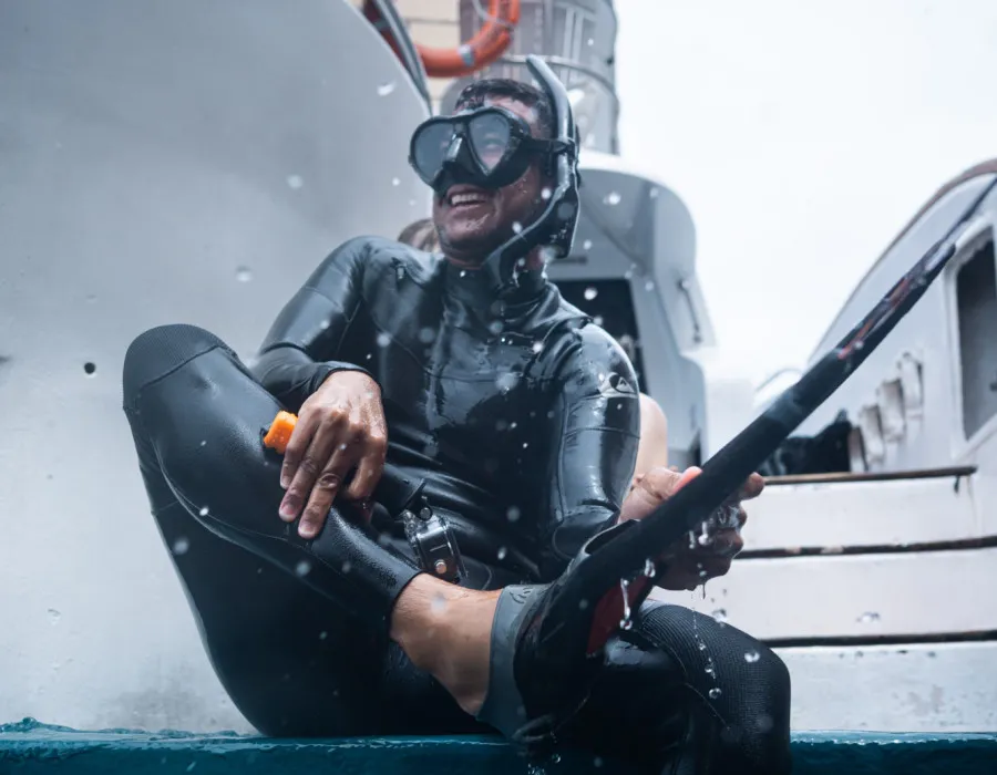 Man sat on edge of boat in snorkeling gear