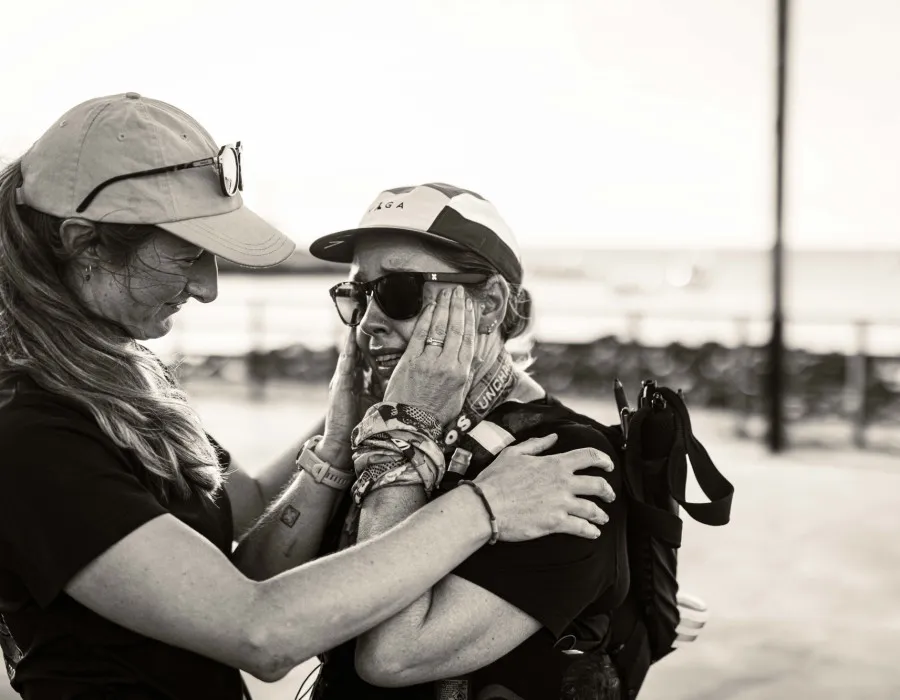 Woman smiling and comforting second woman who is crying