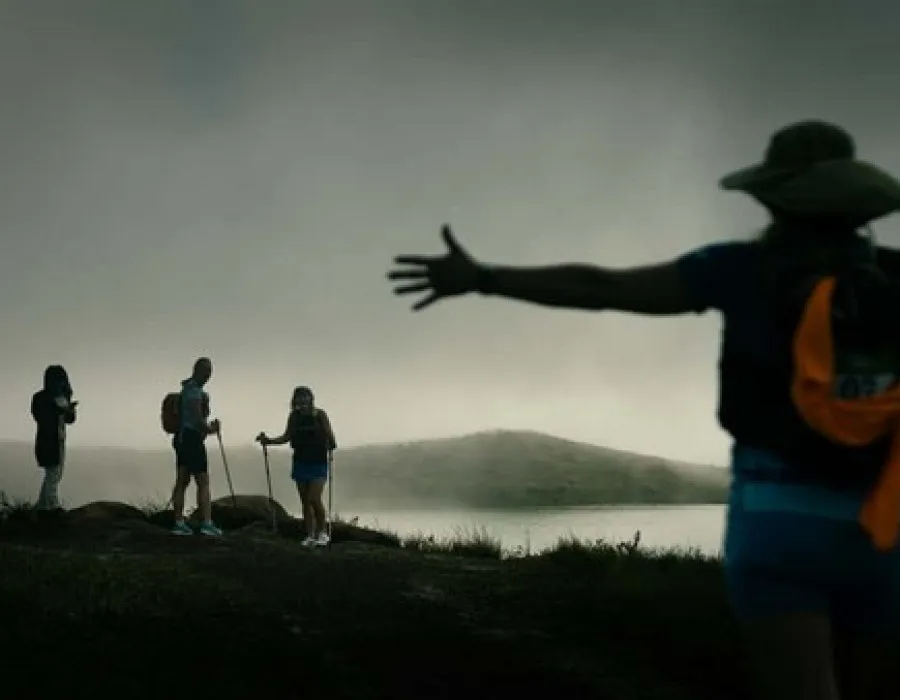 Three participants stood in distance and one closer person holding their arms out