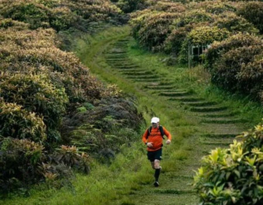 Participant running down grassy track