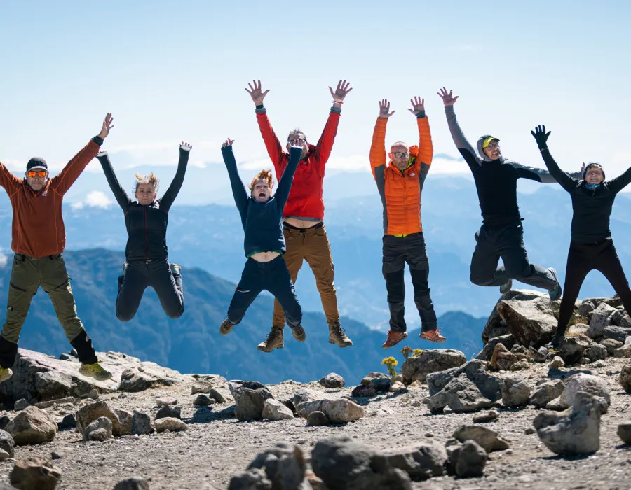 Participants wearing colourful clothing and jumping with their hands in the air