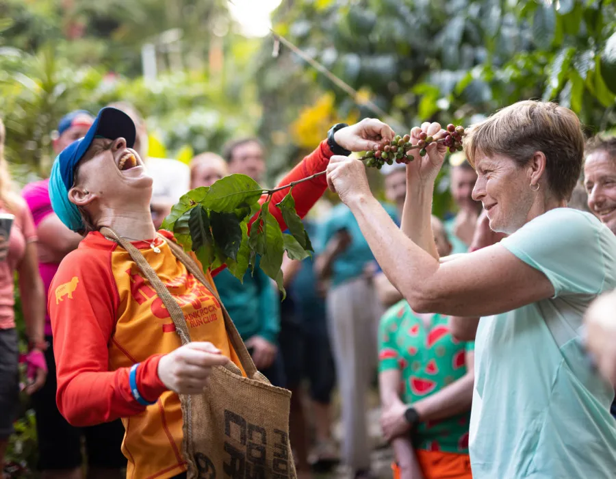 Two women holding fruit and laughing