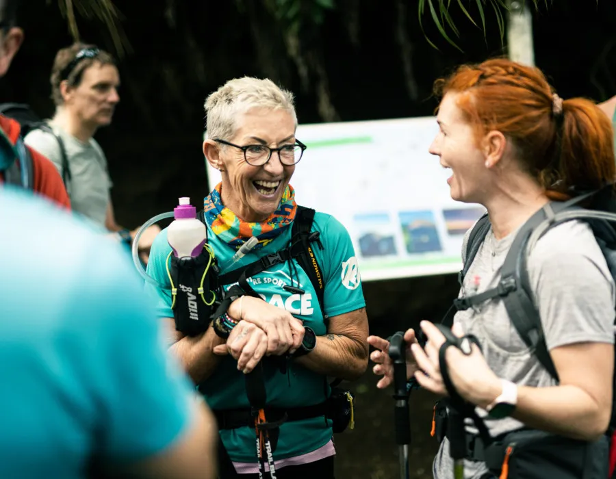 Two women laughing and surrounded by people