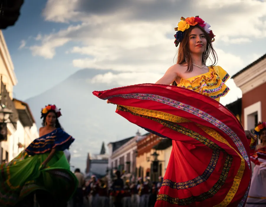 Performers wearing colourful clothing, dancing in the street