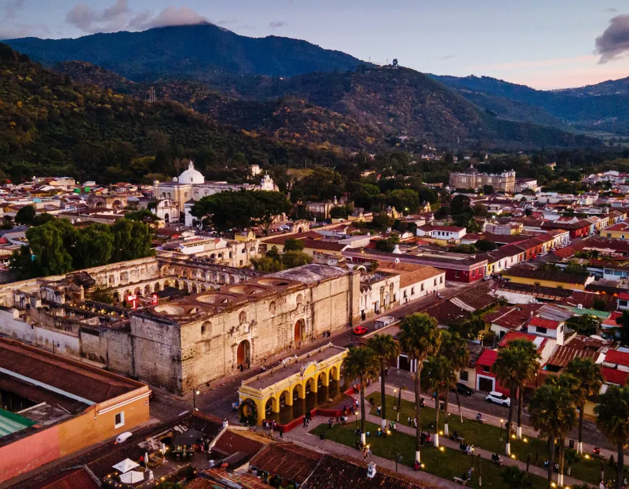 Colourful town with mountains in the background, covered in trees