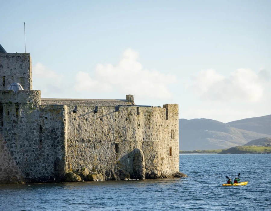 Participants kayaking past stone building
