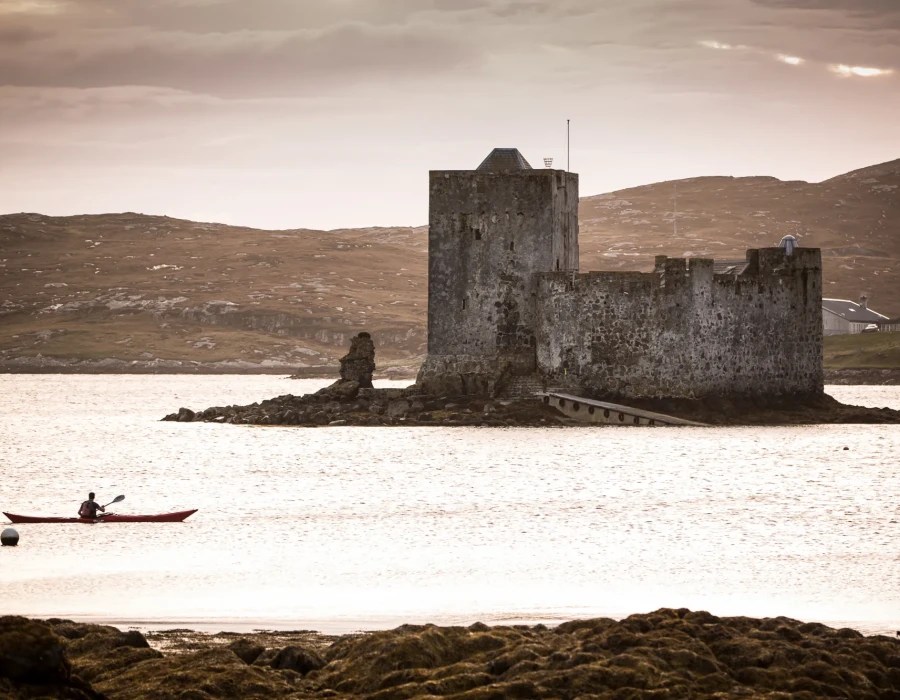 Participant kayaking past stone building