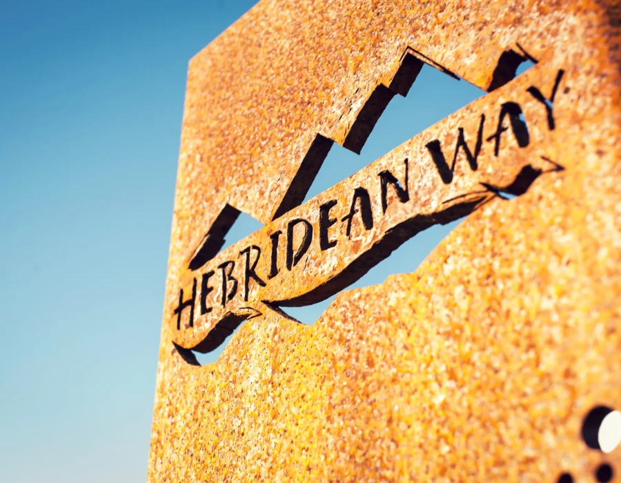 'Hebridean Way' rusty sign and bright, blue sky behind