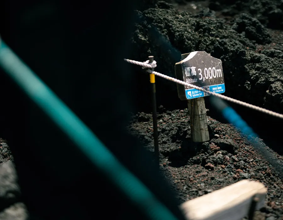 Rope and sign on rocky, dark ground