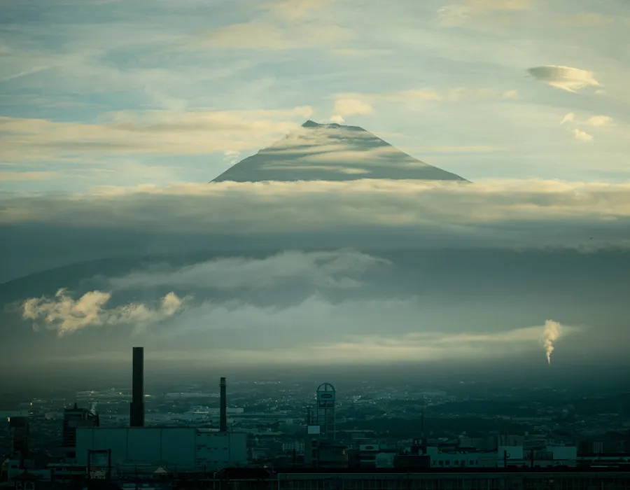 City below and Mount Fuji poking through clouds in the background