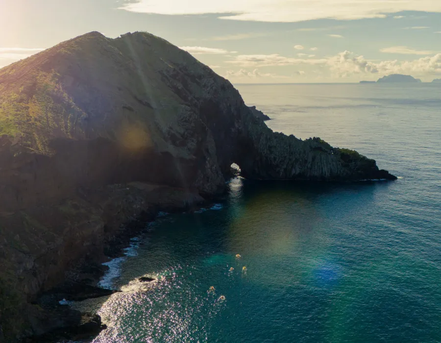 Rocky cliff surrounded by bright, clear water