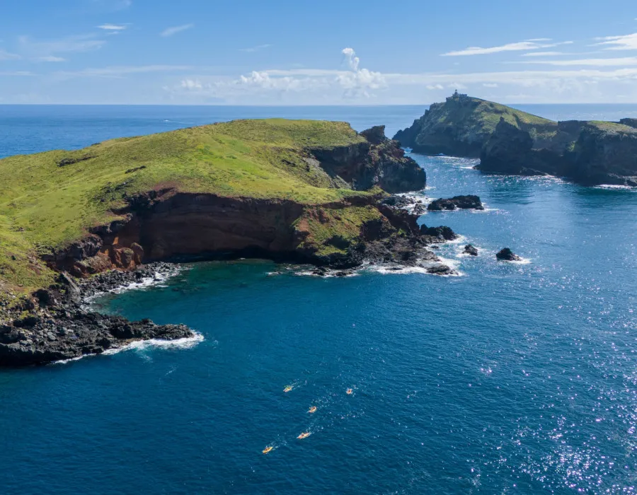 Rocky cliff surrounded by bright, clear water