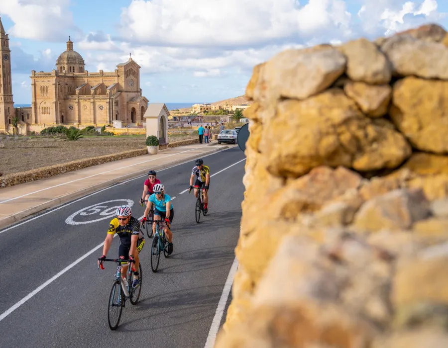 Cyclists riding past grand buildings