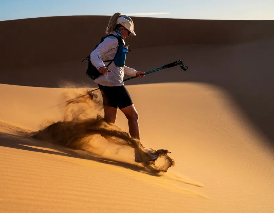 Woman running down sand dune