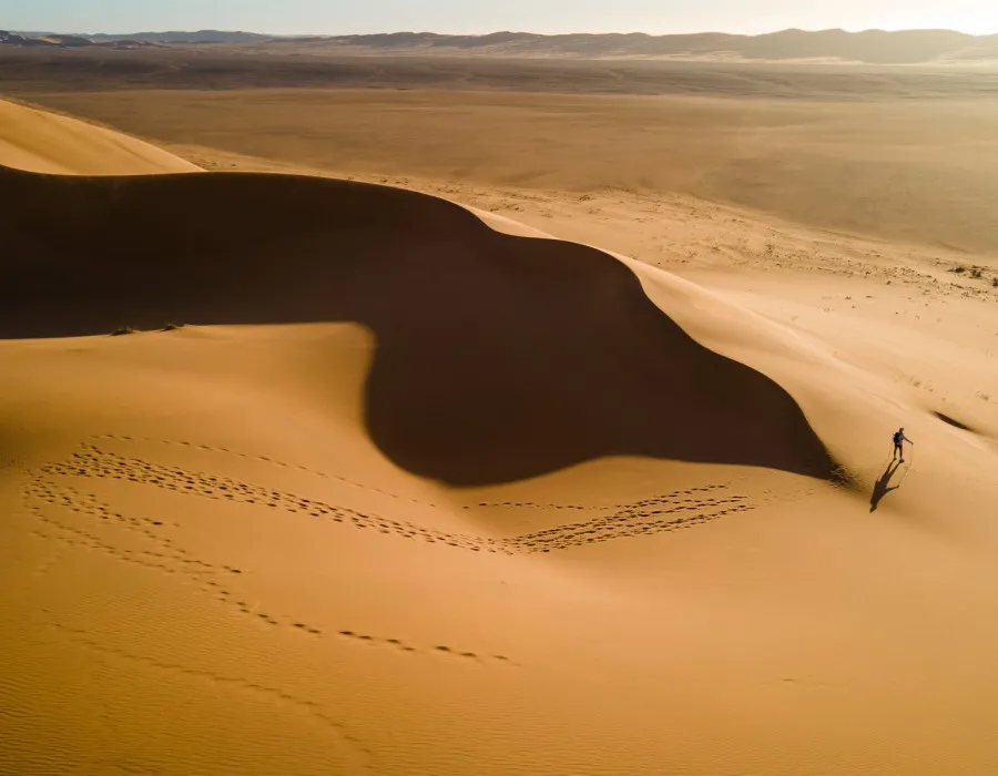 Participant walking over sand dunes