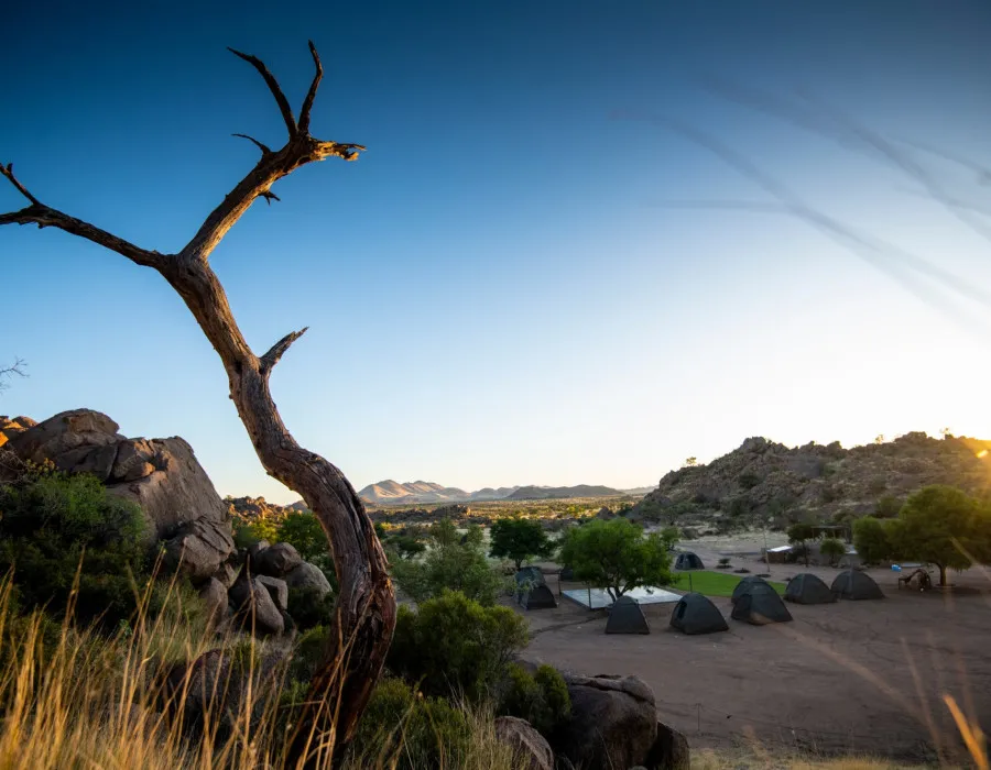 Tents surrounded by dry, rocky terrain