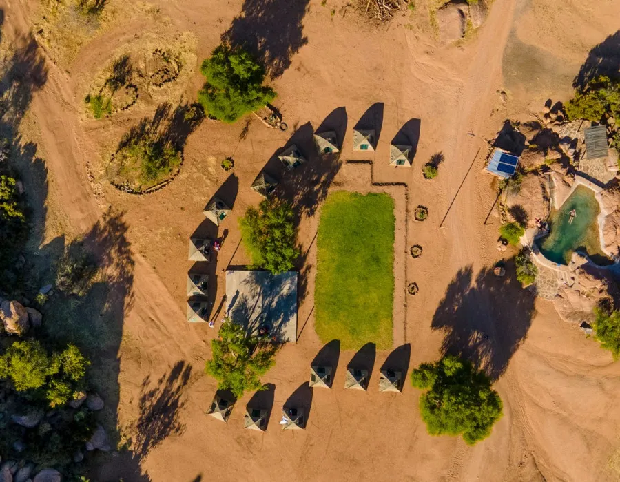 Aerial view of tents, sand and sparse trees