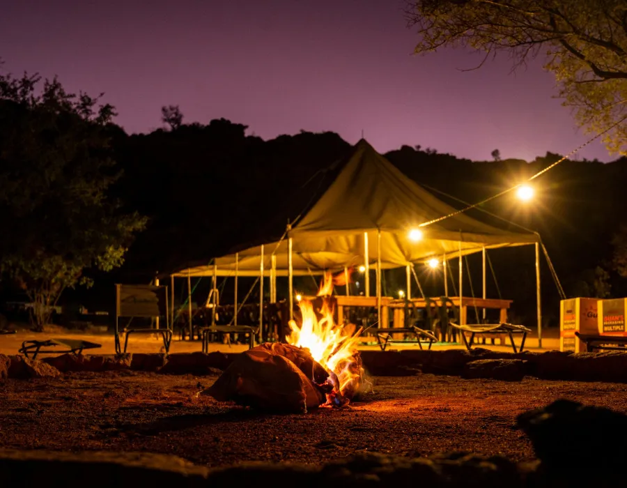 Fire, surrounded by chairs and gazebo behind
