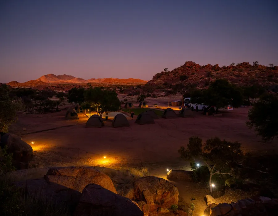 Campsite at night, surrounded by rocky terrain