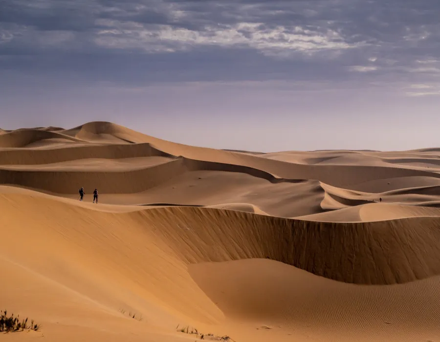 Participants running over smooth sand dunes