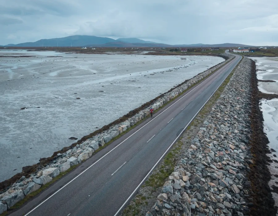 Road through water and mountains in the distance