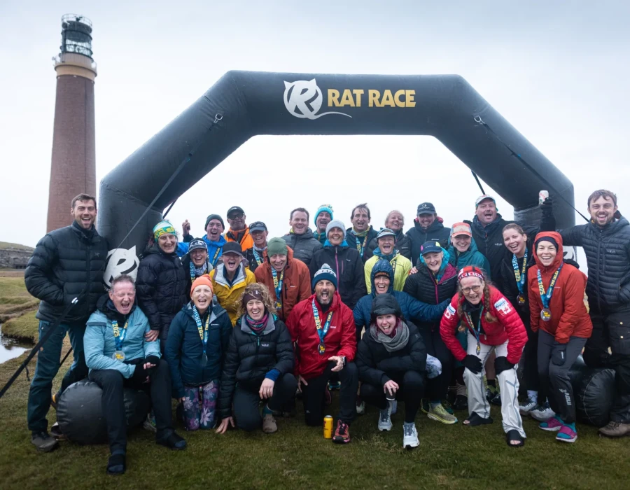 Participants smiling beneath Rat Race arch