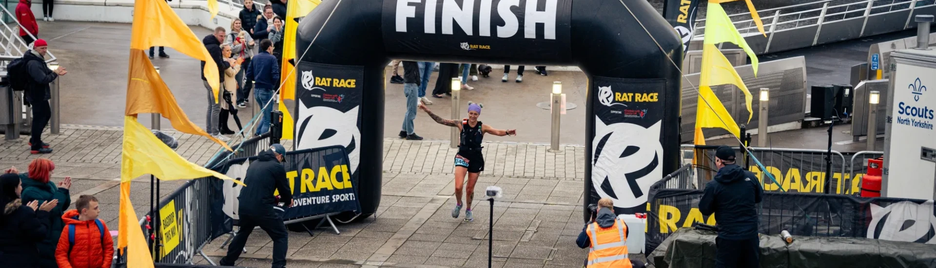 Woman running through finish arch