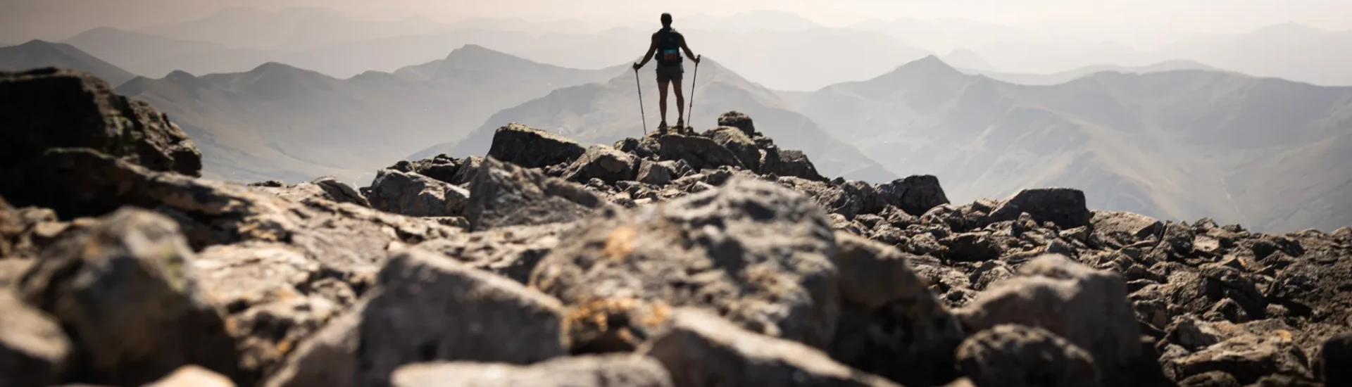Participant stood on rocks, looking out at mountains