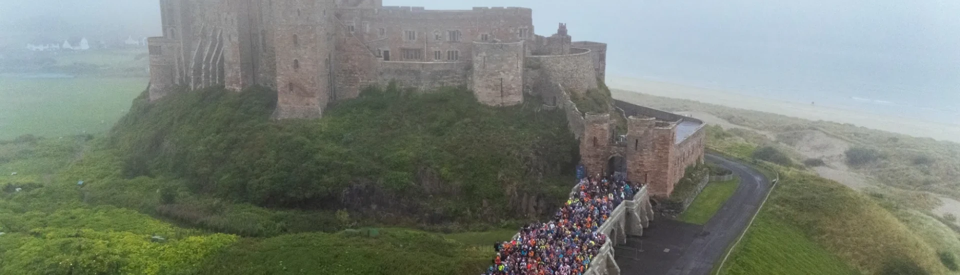 Lots of people waiting at start line outside Bamburgh Castle