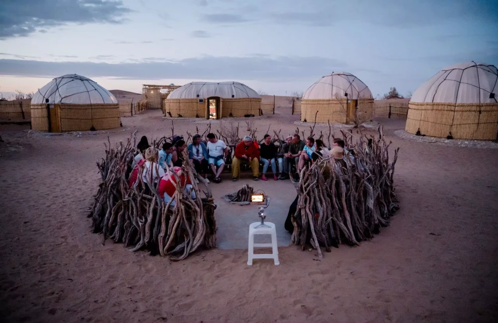 Participants gathered round and yurts in background