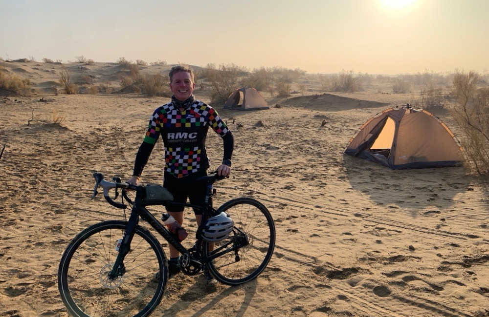 Man stood with bike infront of tent