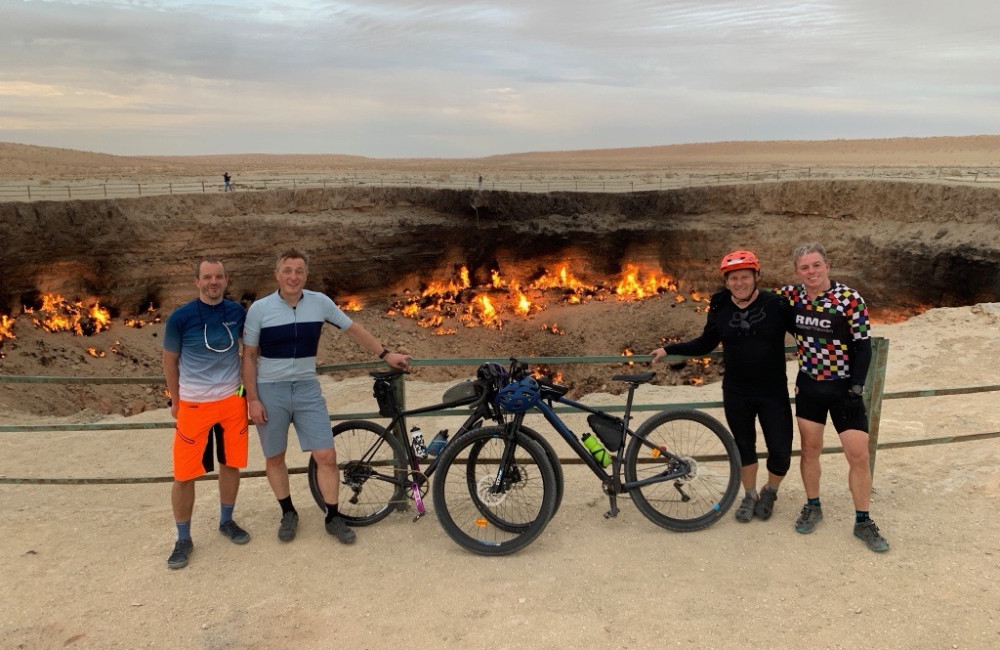 Men stood with bikes by crater