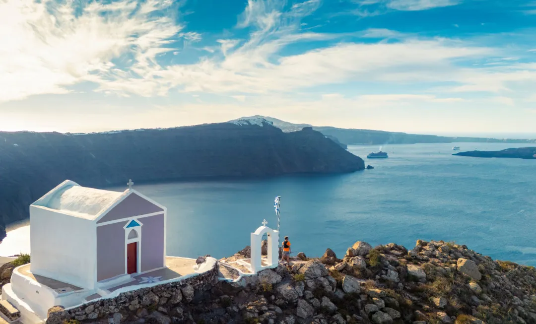 White building on edge of land and sea behind