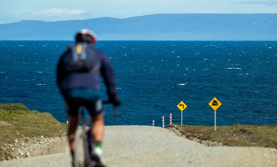 Cyclist riding along track towards water