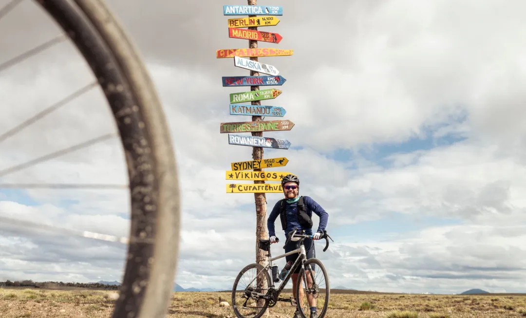 Man stood infront of signs pointing to different places